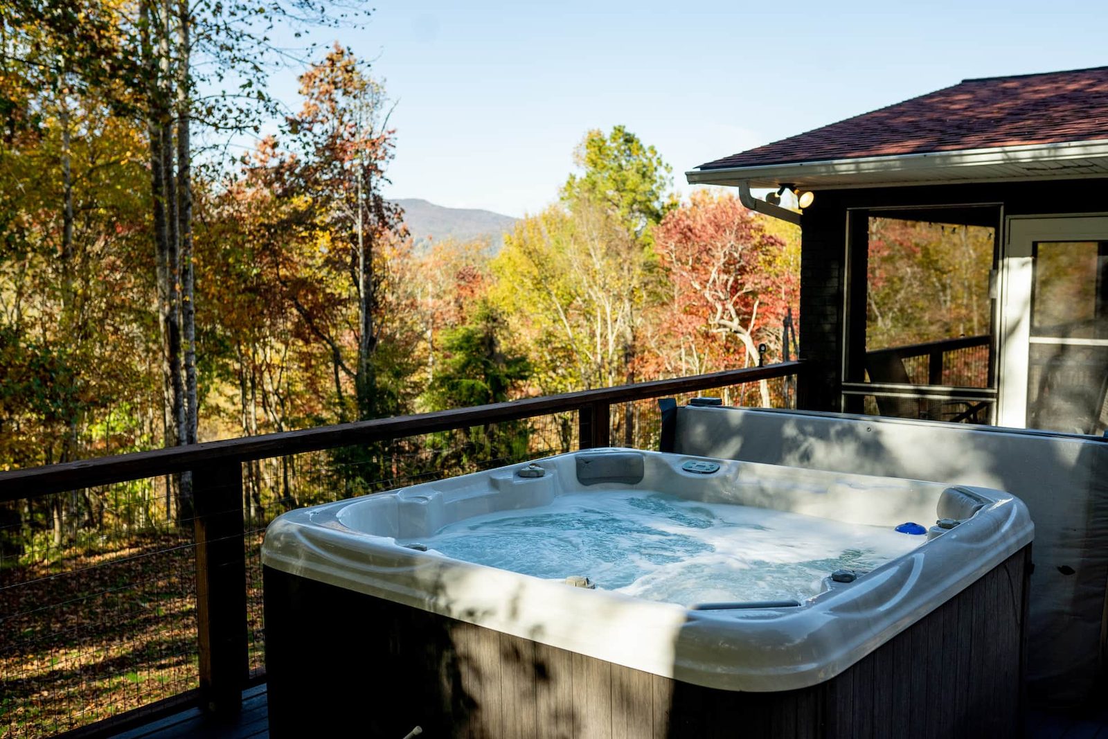Hot tub on a deck overlooking autumn mountains at Big Rock Falls near Asheville